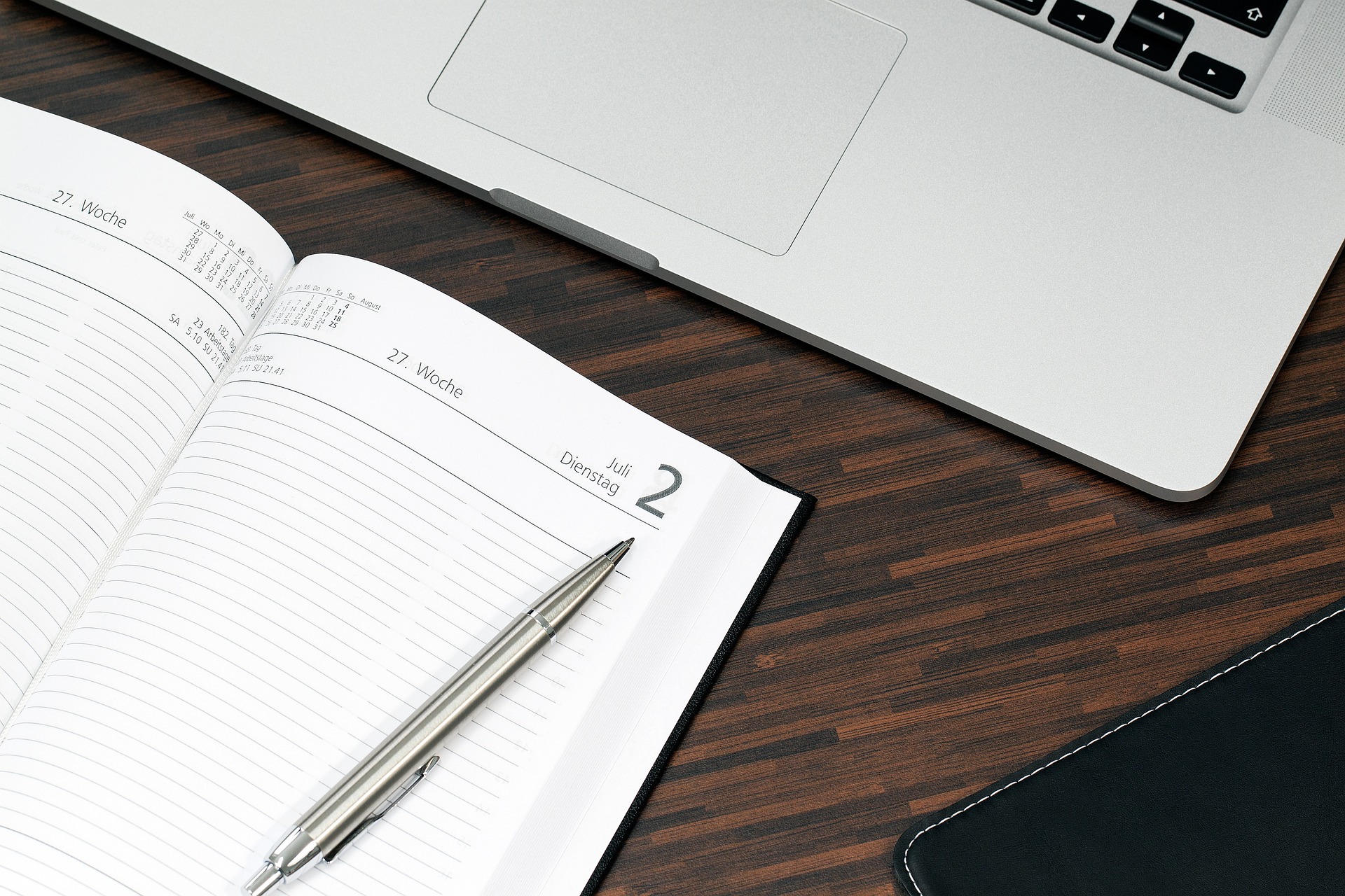 laptop and a schedule book on a table